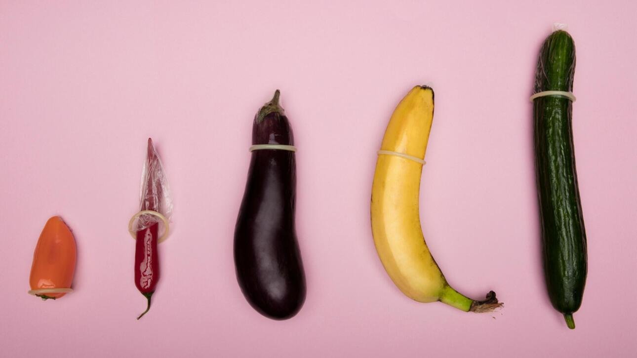 Various fruits and vegetables demonstrating condom use as a visual representation of safe sex practices to prevent STDs.