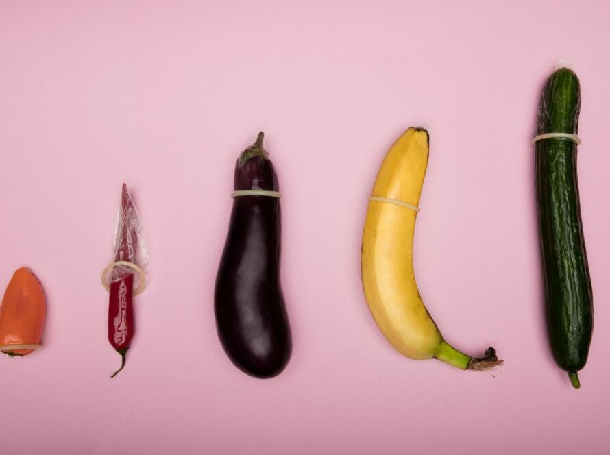 Various fruits and vegetables demonstrating condom use as a visual representation of safe sex practices to prevent STDs.