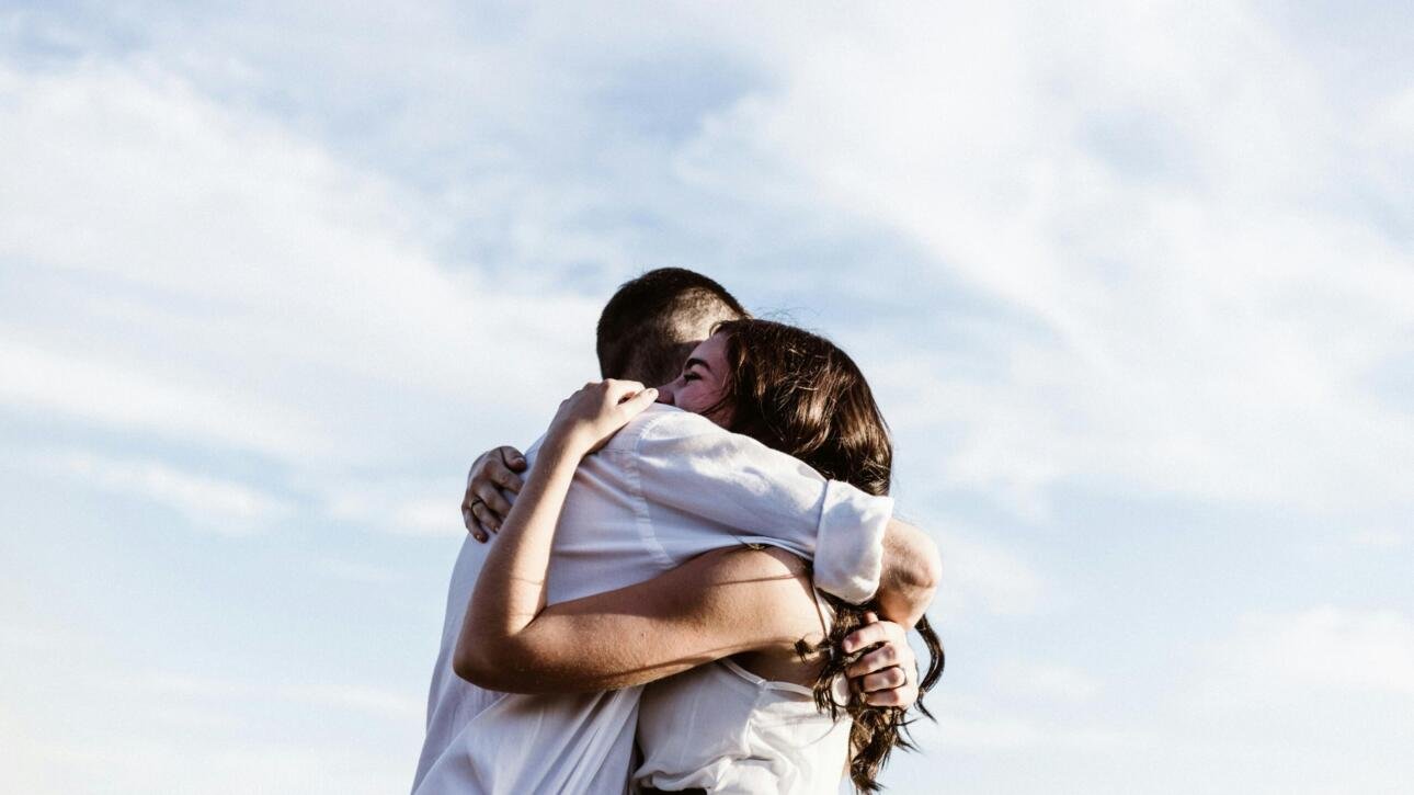 Couple hugging while discussing STD testing in a healthy relationship. Learn how to talk to your partner about STD testing with confidence and care.