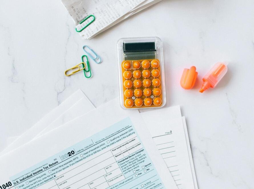 Desk overhead view with tax documents, calculator, and pen illustrating onlyfans taxes for content creators